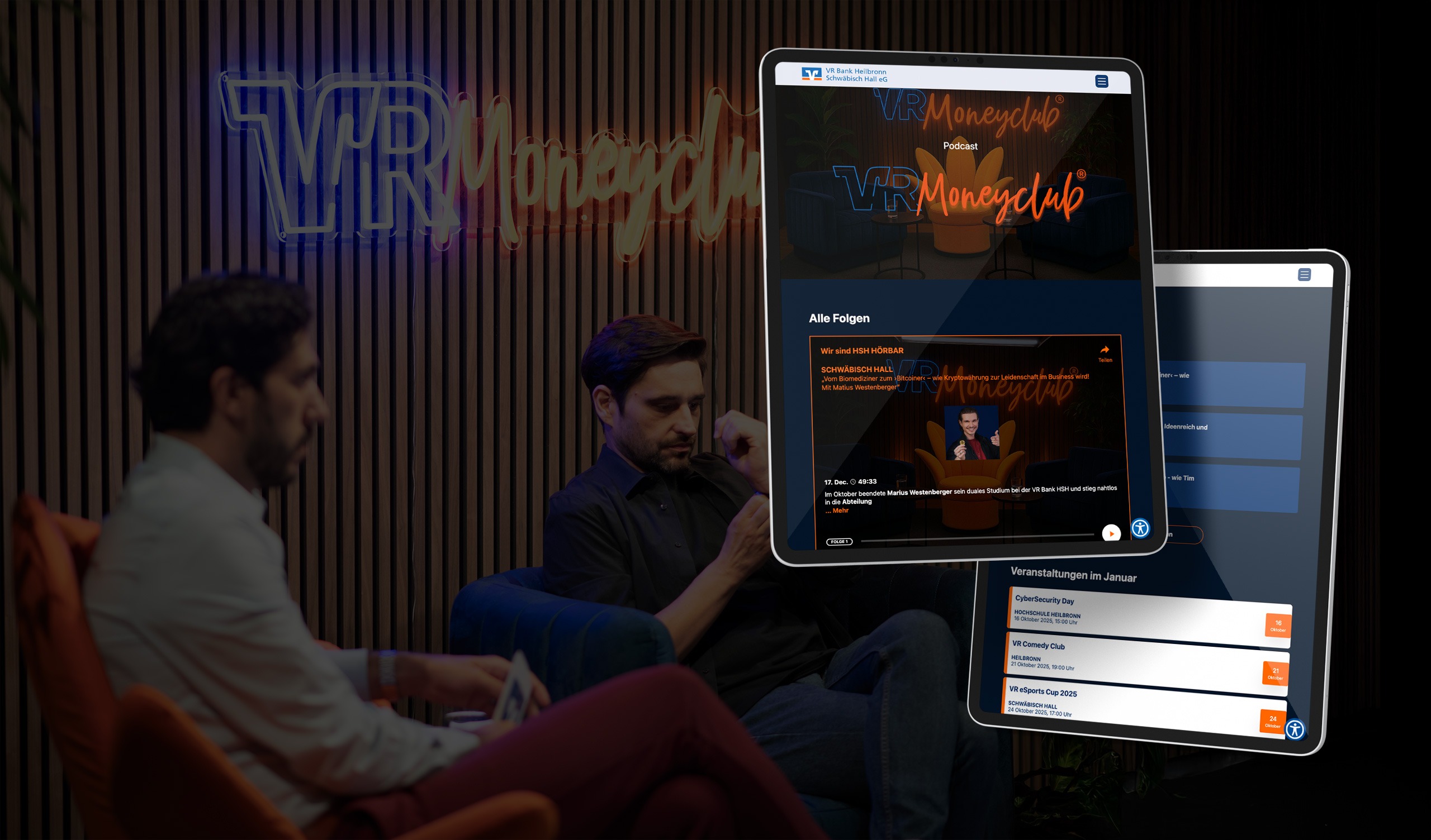 Zwei Männer sitzen im Studio vor VR Moneyclub-Leuchtschrift, im Vordergrund Tablets mit Podcast- und Eventinfos der VR Bank.